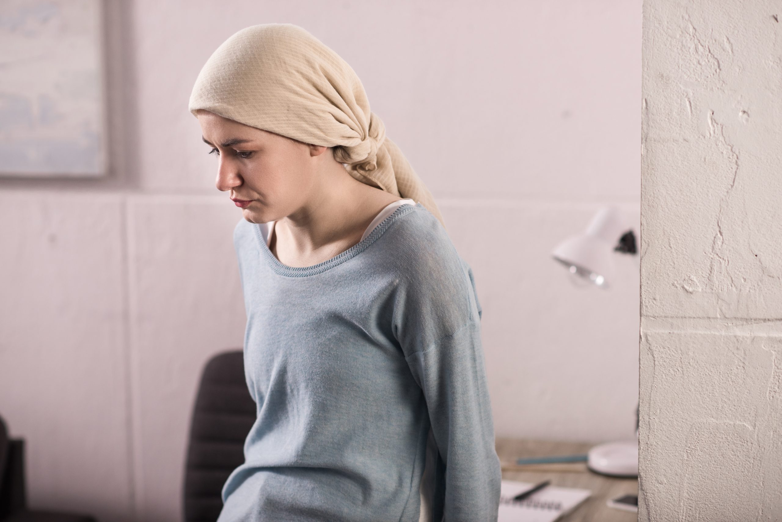 Woman in tichel looking sad.