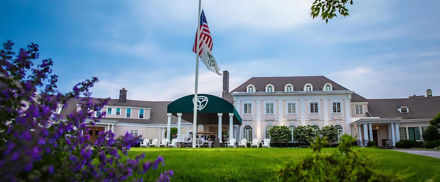 Beautiful Golf club entrance with green awning and American Flag.